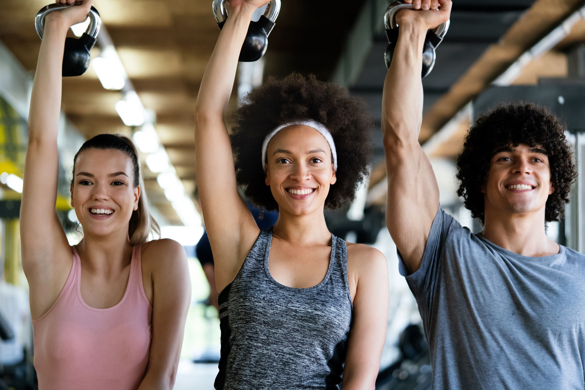 Group of happy multiracial friends exercising together in gym